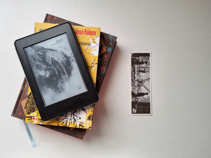 Foto de dois livros empilhados com um kindle acima.